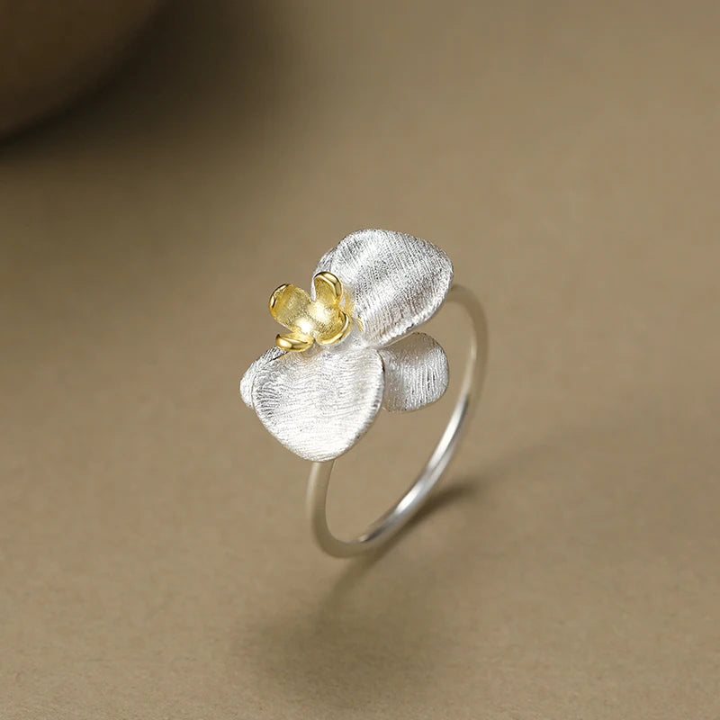 Silver ring with a yellow gemstone on a beige background