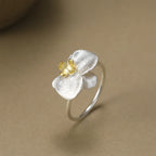 Silver ring with a yellow gemstone on a beige background